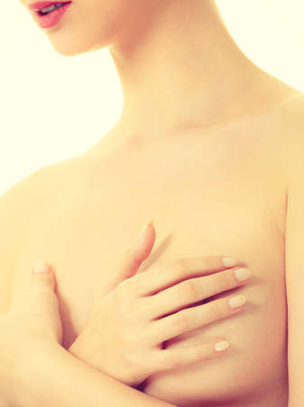 Health care, medicine, female controlling for cancer. Young topless woman covering her breast with handsの写真素材