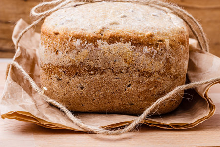 Food. Closeup freshly baked loaf of bread on baking paper