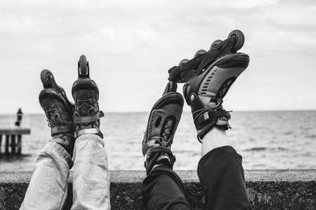 Closeup of people friends with roller skates. Woman and man relaxing outdoor.の写真素材