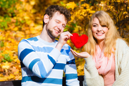 Expressing feelings and affection. Confess love with romantic gesture. Young couple sit on bench in...