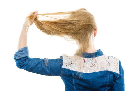 Hairstyle and hairdo. Haircare concept. Back view of blonde woman playing with straight long hair....