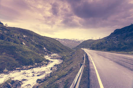 Road running through norwegian mountains. Beautiful landscape. Travel and tourism.の写真素材