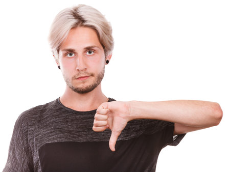 Young man, sad male student giving thumb down gesture. Negative emotion