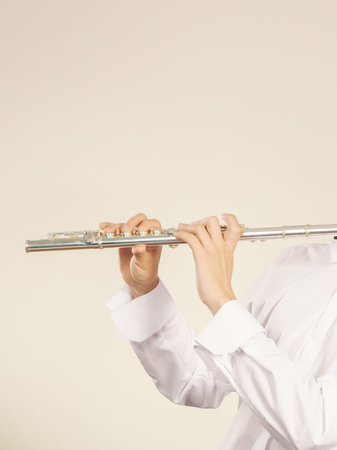 Flute music playing professional male flutist musician performer. Young elegant guy holding instrument in hands. Copy space for textの写真素材