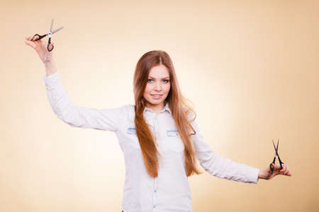 Cutting as a way of healthy strong hair. Girl barber with scissors ready to trimming. Female stylist holds trimmers prepared to haircut.の写真素材