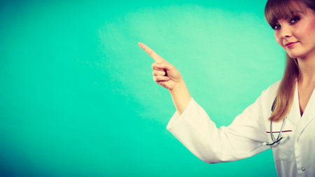 Medicine and healthcare. Portrait of young smiling female doctor. Woman professionalist in white medical uniform showing copy space.の写真素材