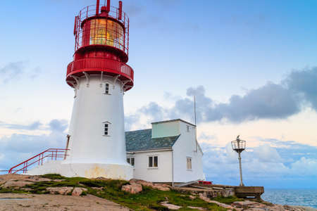 Historic red white lighthouse on the edge of rocky sea coast, South Norway, Lindesnes Fyr beaconの写真素材