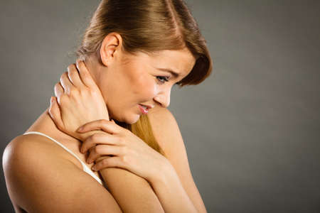 Feeling exhausted, back and spine disease. Woman having bad ache. Female placing hands on her neck suffering from painの写真素材