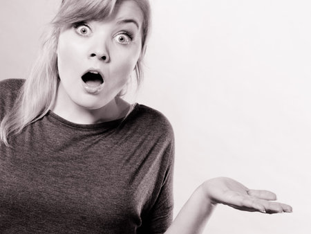 Shock and disbelief concept. Surprised astonished girl with wide open mouth. Amazed female looking very shocked. Facial expression and body language.の写真素材