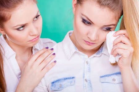 Young woman is sad crying and being consoled by friend. Girl comforting her sister. Mental problems depression and fatigue.の写真素材