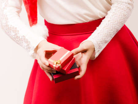 Closeup of woman with gifts in studio on gray. Christmas xmas season.の写真素材