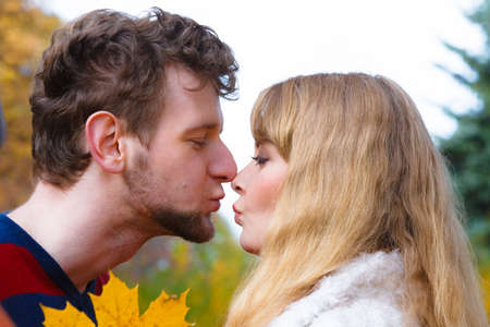 Love relationship dating and people concept - close up couple kissing in autumn parkの写真素材