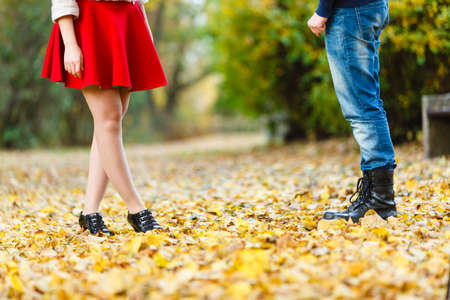 Fashion footwear dating romance love youth outdoor concept. Young lady meeting rough boy. Elegant girl in glamour shoes with man in jeans boots.の写真素材