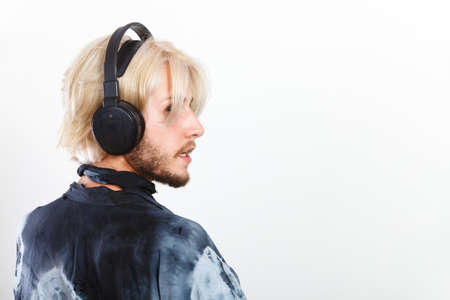 Young people, relax and passion concept. Passionate music lover stylish guy with headphones listening music, relaxing enjyoing, studio shot on white copy spaceの写真素材