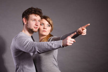 Fear and scare. Two young terrified scared people. Stressed woman and man showing to copy space. Couple afraid of bad things war.の写真素材