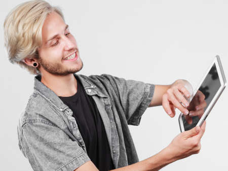 Education social media. Modern technology internet concept. Stylish handsome young man using tablet computerの写真素材