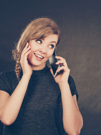 Flirt and romance. Begin of relatinship. Attractive blonde woman flirting texting on mobile phone smartphone. Gorgeous girl keep in touch with her lover by messages and calls.の写真素材