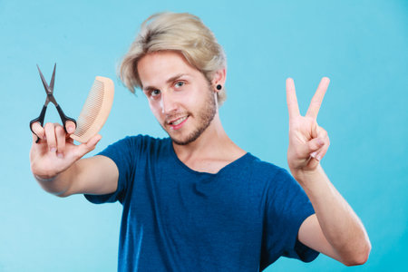 Style and fashion. Young trendy male hairstylist barber with new idea of look changing. Blonde guy...