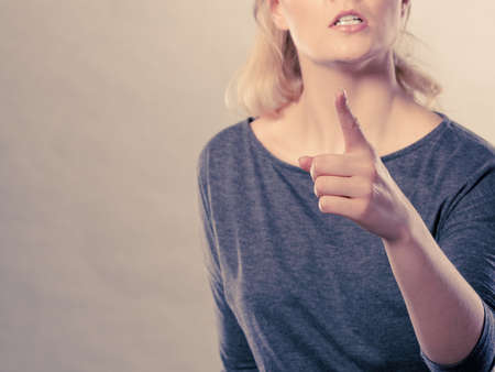 Anger and rage concept. Young expressive woman show her bad face. Angry nervous annoyed girl portrait. Human full of negative emotions.の写真素材