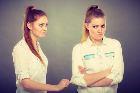 Young woman asking apologize to her offended friend after quarrel. Interpersonal conflict, bad relationships, friendship difficulties concept.の写真素材