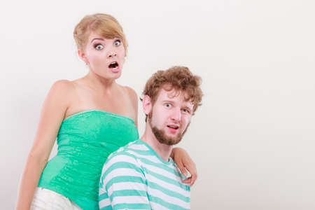 Funny playful young couple making silly face blonde girl and bearded guy studio shotの写真素材
