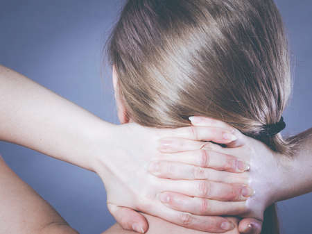 Feeling exhausted, back and spine disease. Woman having bad ache. Female placing hands on her neck suffering from painの写真素材