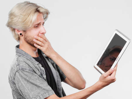 Education social media. Modern technology internet concept. Stylish handsome young man using tablet computer, thinkingの写真素材