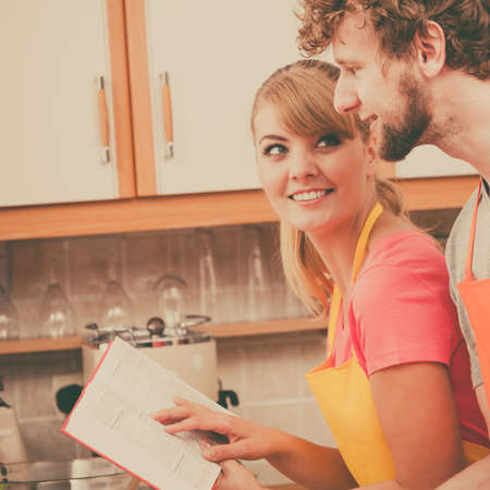 Couple in kitchen cookingの写真素材