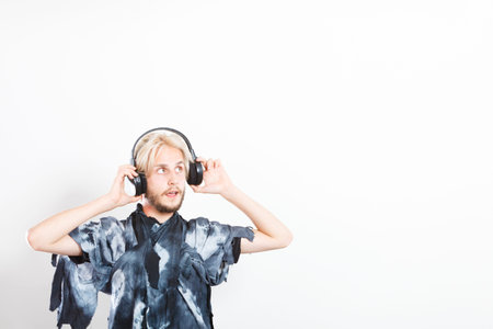 Young people, relax and passion concept. Passionate music lover stylish guy with headphones...