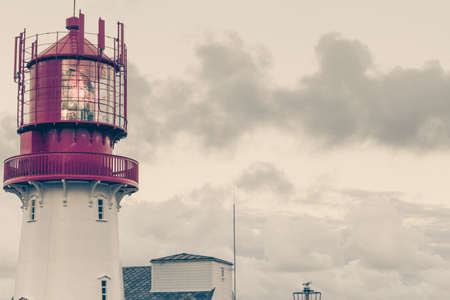 Historic red white lighthouse on the edge of rocky sea coast, South Norway, Lindesnes Fyr beaconの写真素材