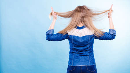 Hairstyle and hairdo. Haircare concept. Back view of blonde woman playing with straight long hair. Hairstylist barber making coiffure.の写真素材