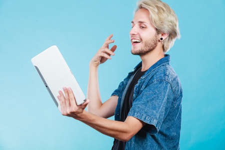 Education social media. Modern technology internet concept. Stylish handsome young guy using tablet computer, on blue colorの写真素材