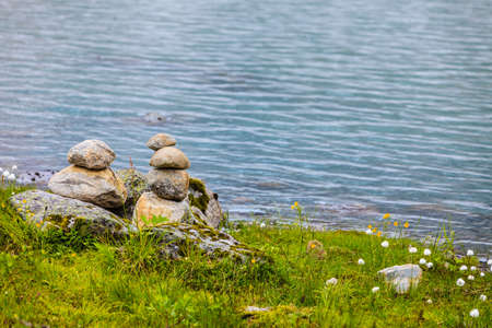 Tourism holidays and travel. Stones stack on lake shore, Norway Scandinavia.の写真素材