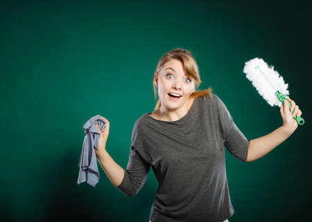 Joy happiness chores cleaning concept. Cheerful lady with household items. Young extatic blonde maid dancing with rag brush.の写真素材