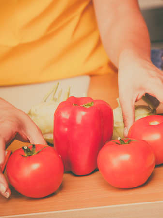 Healthy eating, vegetarian food, cooking, dieting and people concept. Closeup male hands in kitchen preparing fresh vegetables saladの写真素材