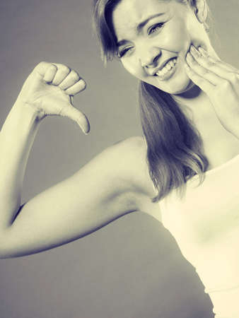 Dental care and toothache. Young woman achy girl suffering from terrible tooth pain, touching pressing her cheek by hand palm.の写真素材