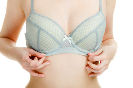 Woman in bra lace lingerie taking care of her breasts, closeup female chest in underwear isolated on whiteの写真素材