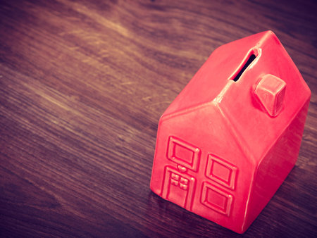 Finance mortgage housing real estate savings concept. House like cash box. Piggy bank in home shape.の写真素材