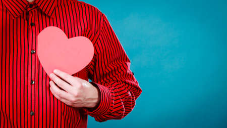 Love hope and help concept. Man holding beautiful red heart in hands. Part body of charity volunteer.の写真素材