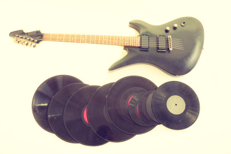 Equipment of musician. Electric electro black guitar string intrument and vinyl records lying ready...
