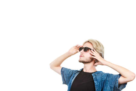 Men fashion, modeling concept. Hipster man wearing jeans outfit and sunglasses looking into space studio shot, isolatedの写真素材