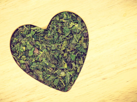 Healthy food, healing herbs, alternative herbal medicine concept. Dried herb nettle leaves in form...