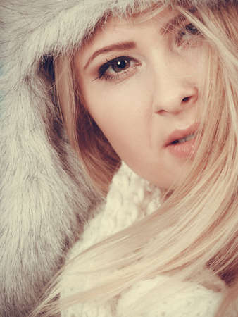 Accessories and clothes for cold days, fashion concept. Blonde woman in winter warm furry hat in russian style and scarf.の写真素材