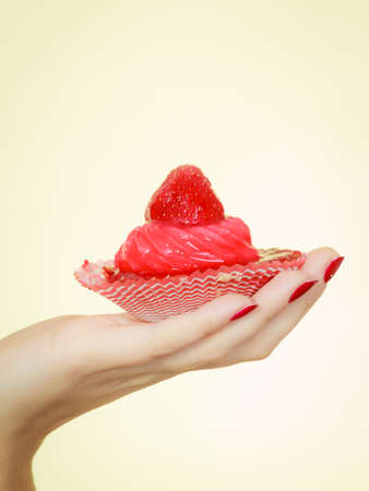 Sweets, junk food, sugar temptation on diet concept. Woman holding sweet delicious cupcakeの写真素材