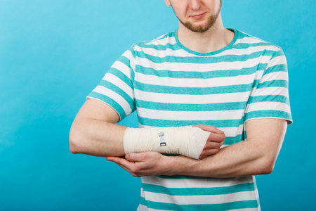 Fractures and dislocations concept. Man with hand in bandage. Helpful medication for painful palm...