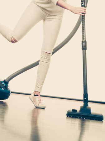 Household cleaning tools and devices, housekeeping duties concept. Woman legs and vacuum cleanerの写真素材