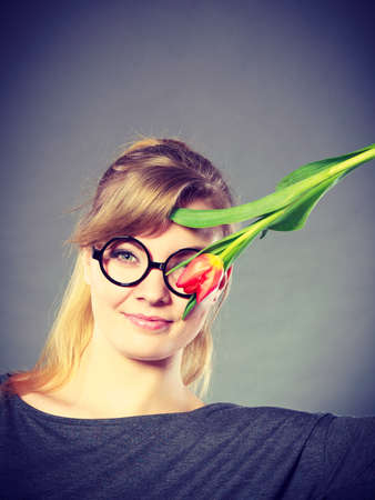 People and nature. Young woman with tulip on her face live in peace with floral world. Girl feel connection to natural environment.の写真素材