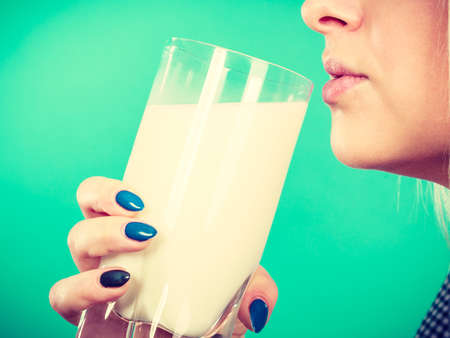 Healthy drinks, good nutrition, perfect breakfast concept. Woman drinking milk from glassの写真素材