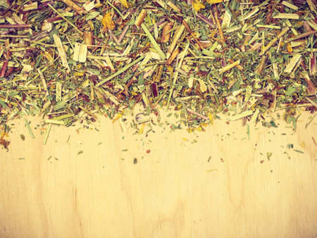 Border frame of assorted natural medical dried herb leaves on wooden board with copy space