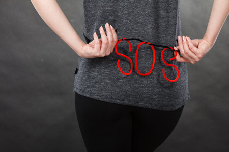Sadness, depression, troubles and domestic violence concept. Woman holding SOS sign, she needs help.